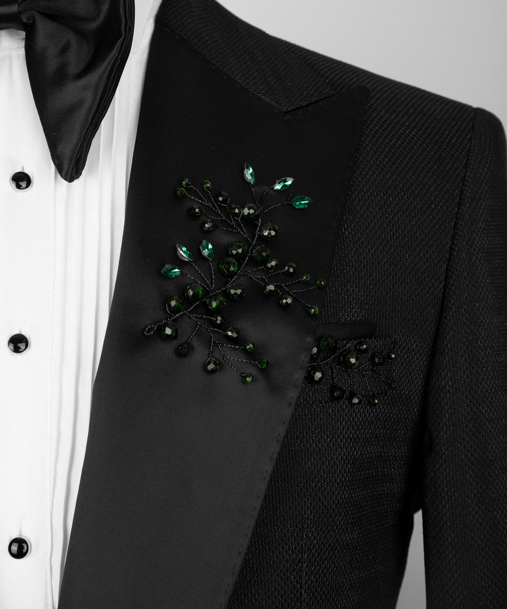 Close-up of black tuxedo breast pocket with green crystal floral embellishment