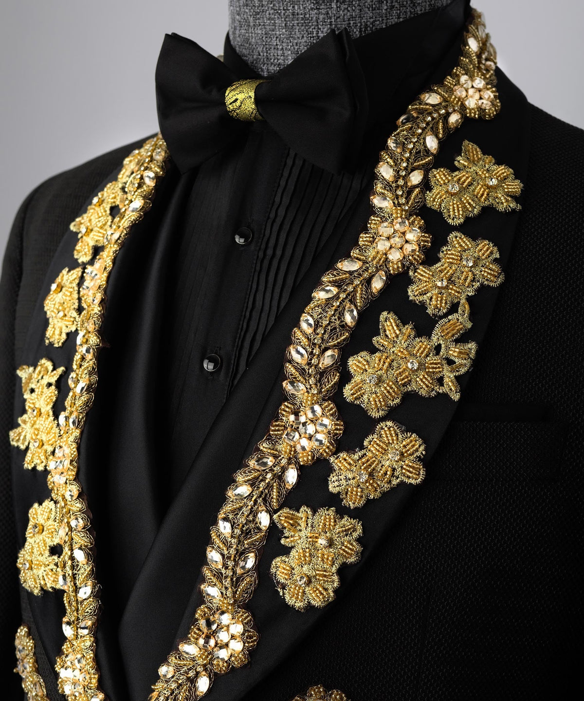 Black tuxedo neckline with gold floral embroidery and black bow accent