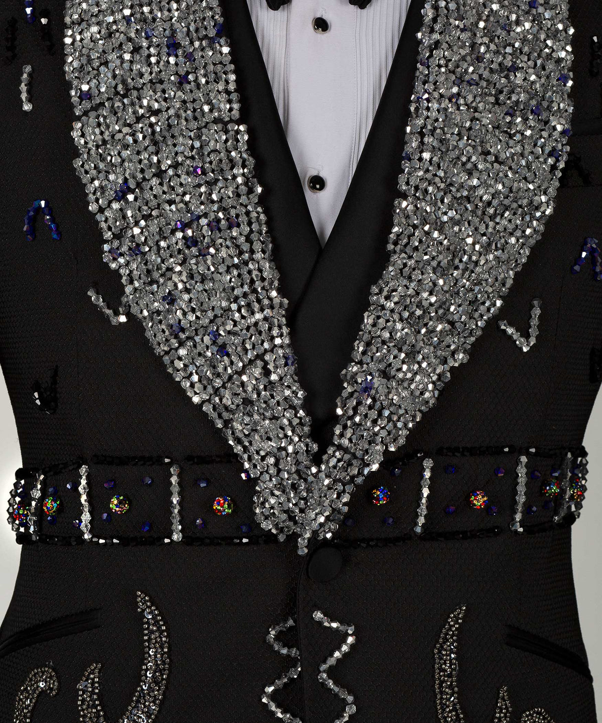 Close-up: sequin lapels with jeweled trim and ornate black vest details