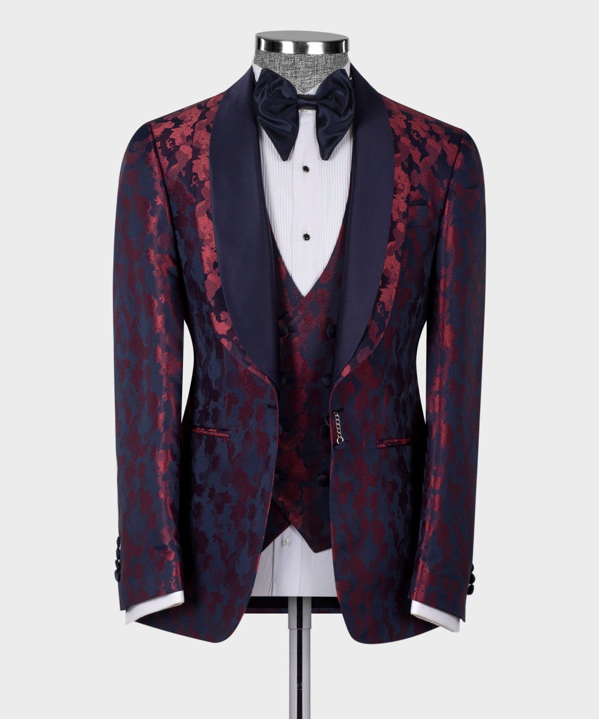 Double-lapel tuxedo jacket with burgundy pattern over dark blue, paired with black bow tie
