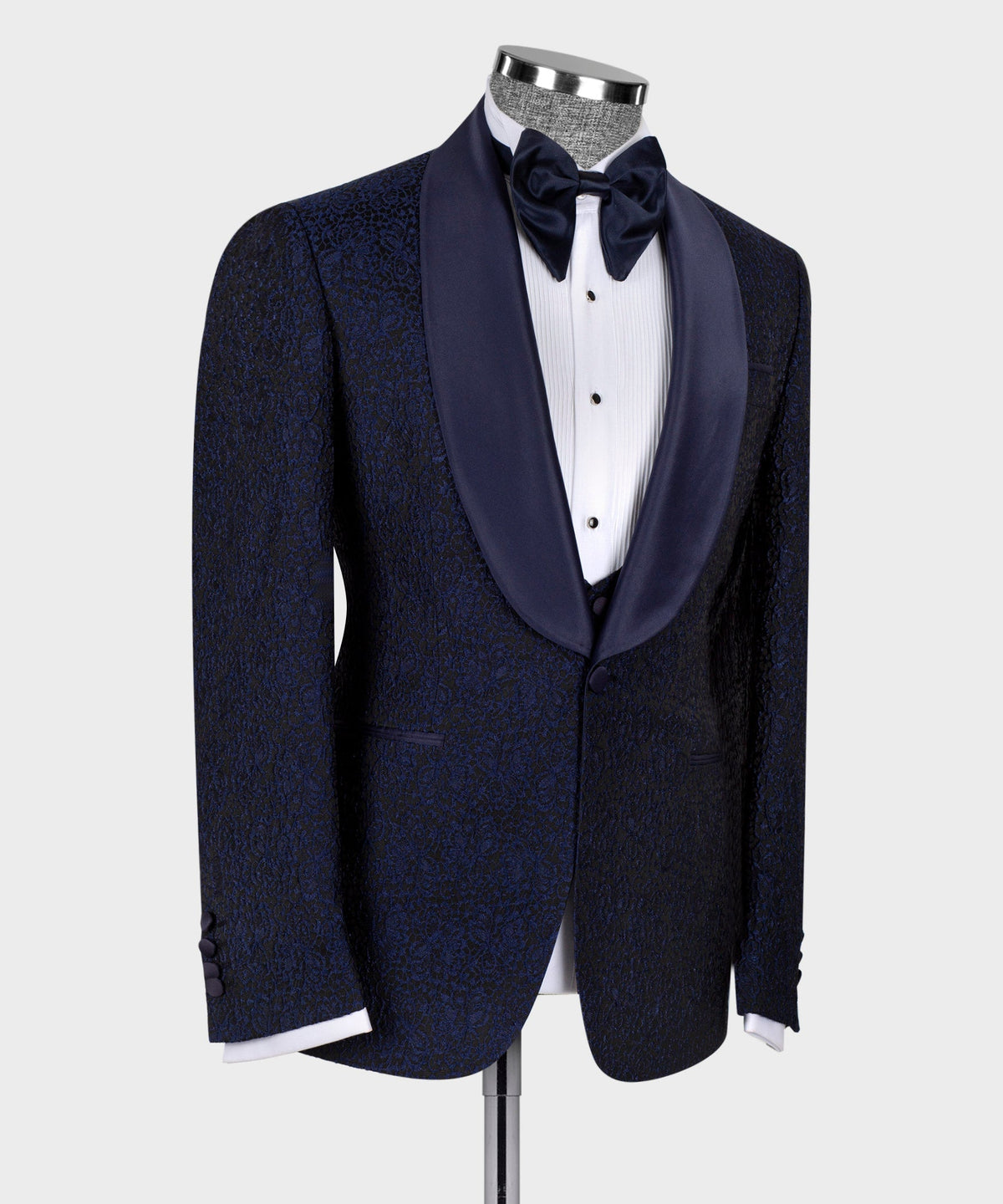 Three-piece tuxedo suit in dark blue: bow tie and satin-trimmed lapels, side view.