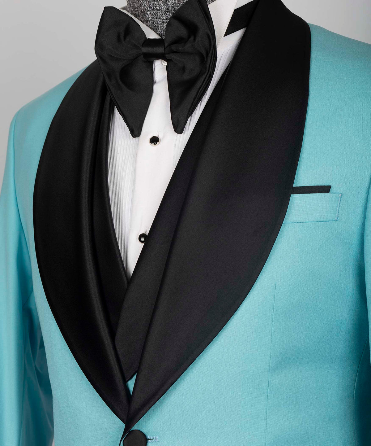 Black satin shawl collar and bow tie over white shirtfront on light blue tuxedo