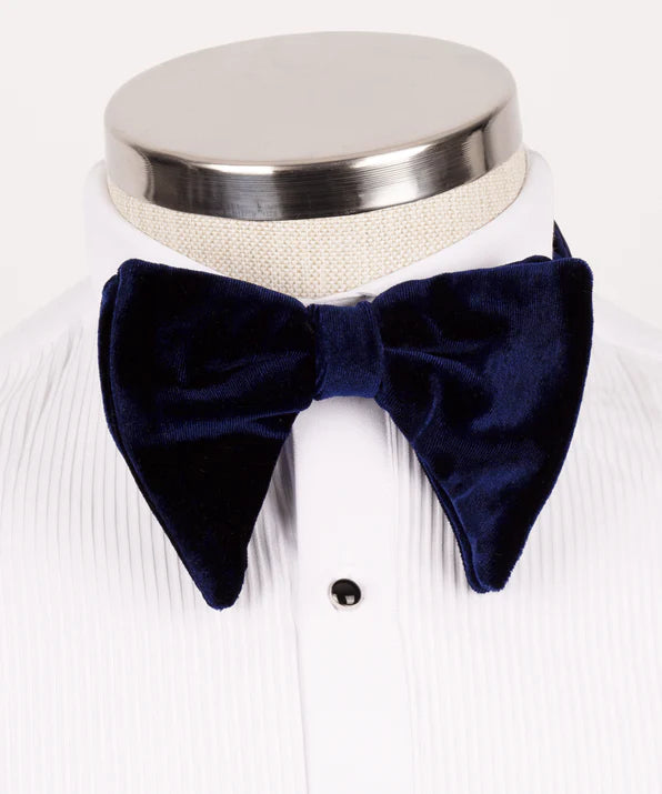 Koss Atelier dark navy blue velvet bow tie with pointed ends, displayed on a white pleated dress shirt.