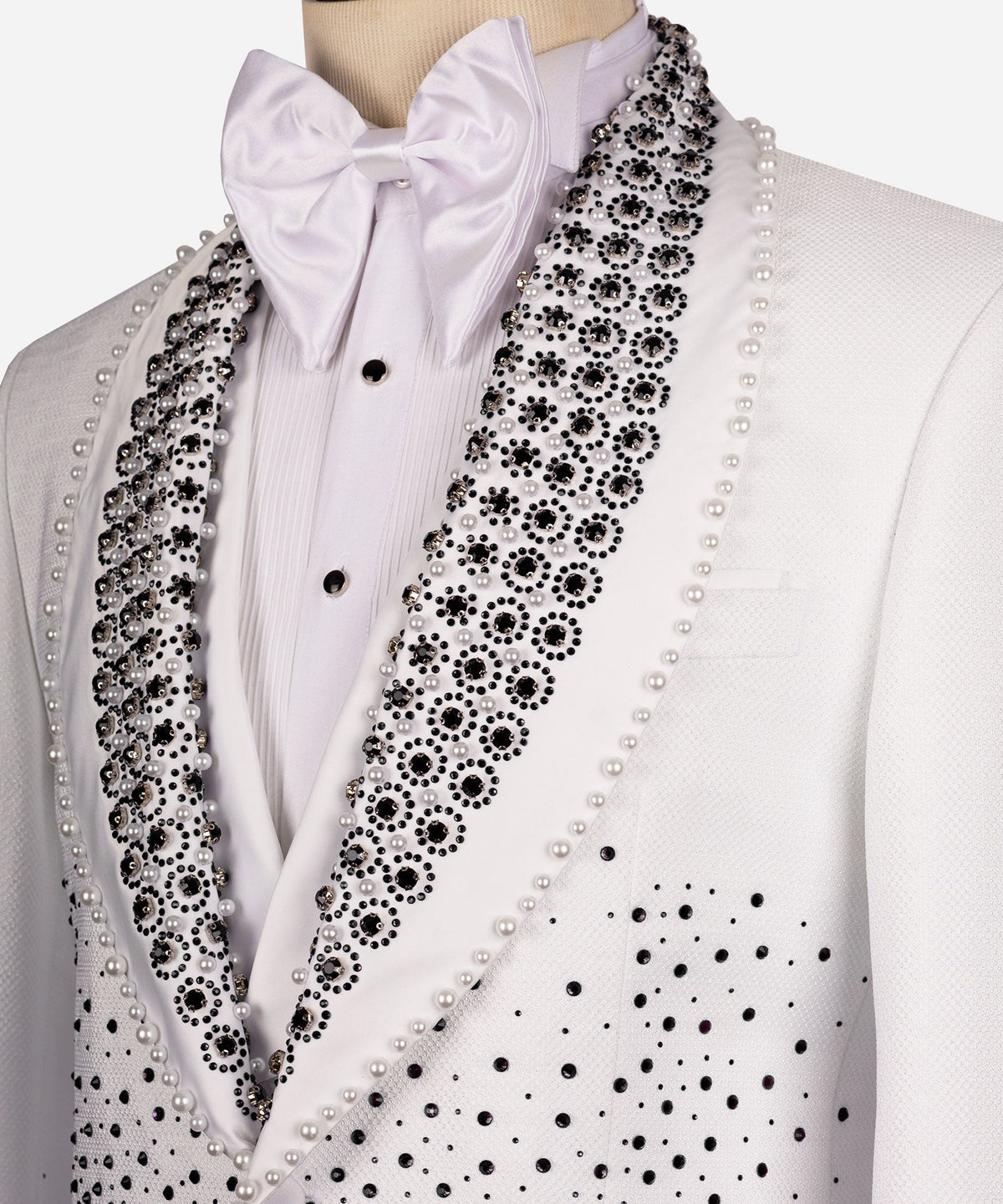 Close-up white tuxedo lapel with black gems and pearl trim, satin bow tie
