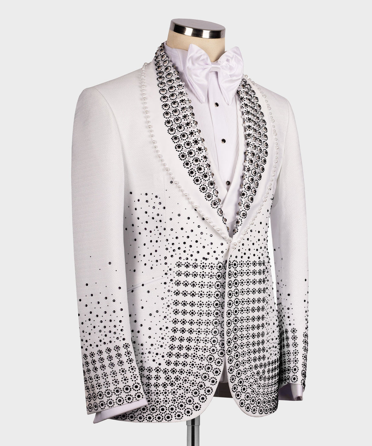 Front view white tuxedo with black beaded detailing, satin bow tie, and buttoned placket