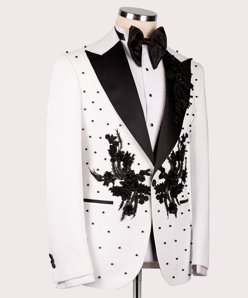 White tuxedo jacket with black satin lapels and large hand-embroidered floral sprays