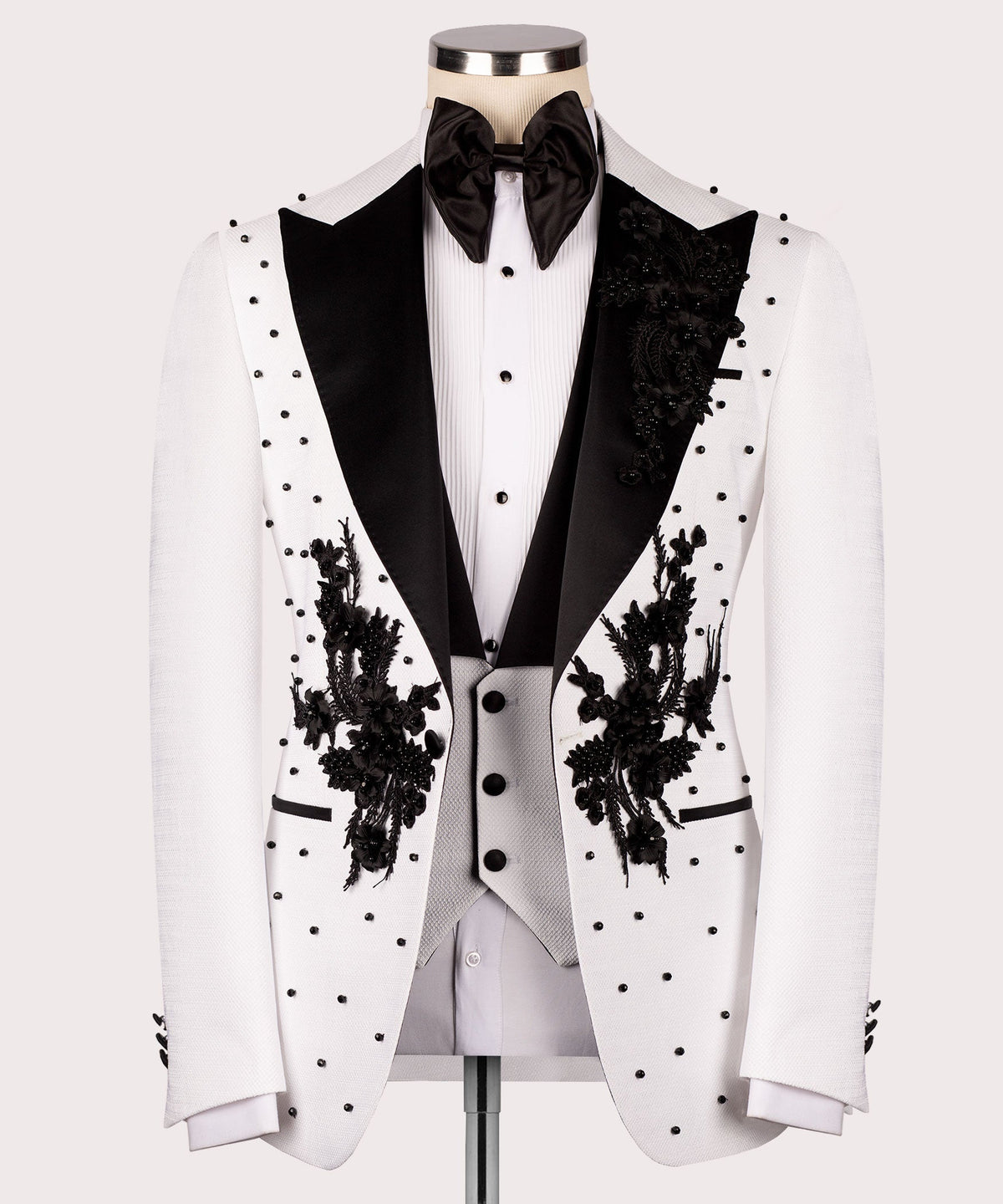White tuxedo jacket front with black satin lapels, floral embroidery, and dot pattern
