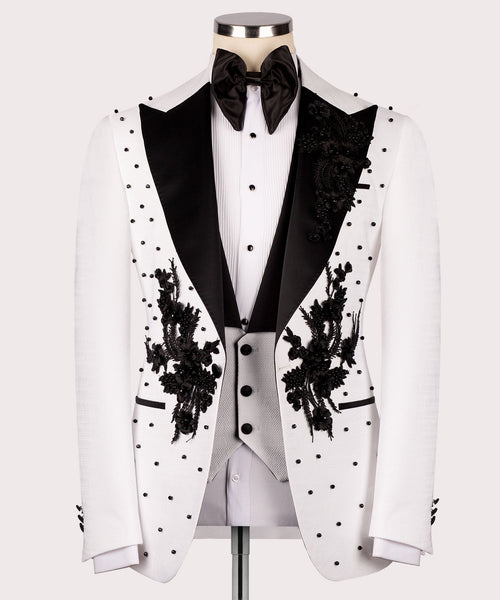 White tuxedo jacket front with black satin lapels, floral embroidery, and dot pattern