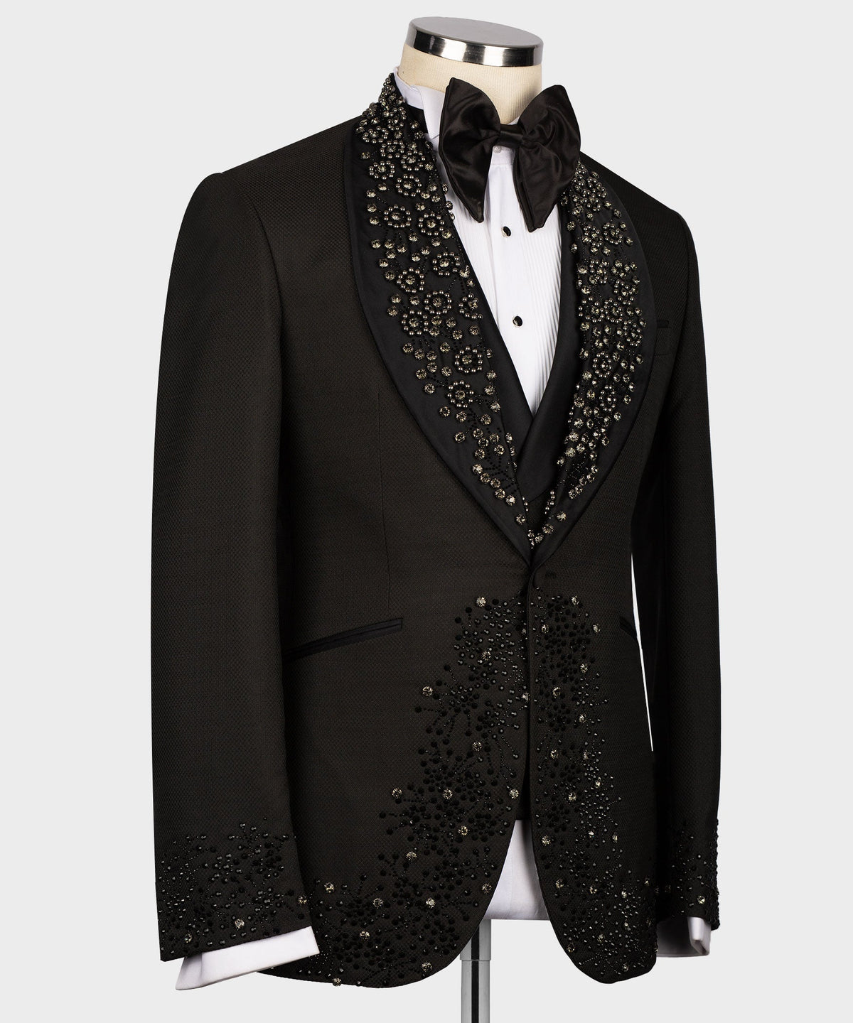 Black tuxedo jacket with ornate gem-stone collar and embellished lapels, satin bow tie