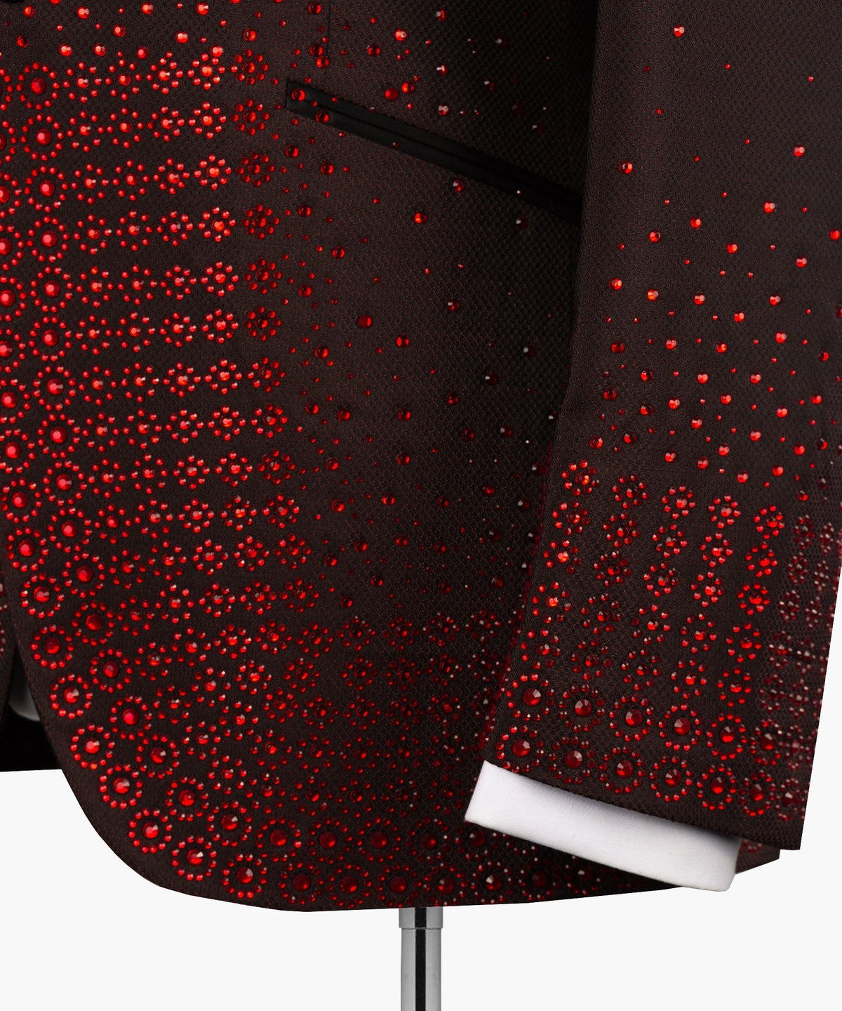Close-up burgundy tuxedo jacket with red circular beadwork across the sleeve