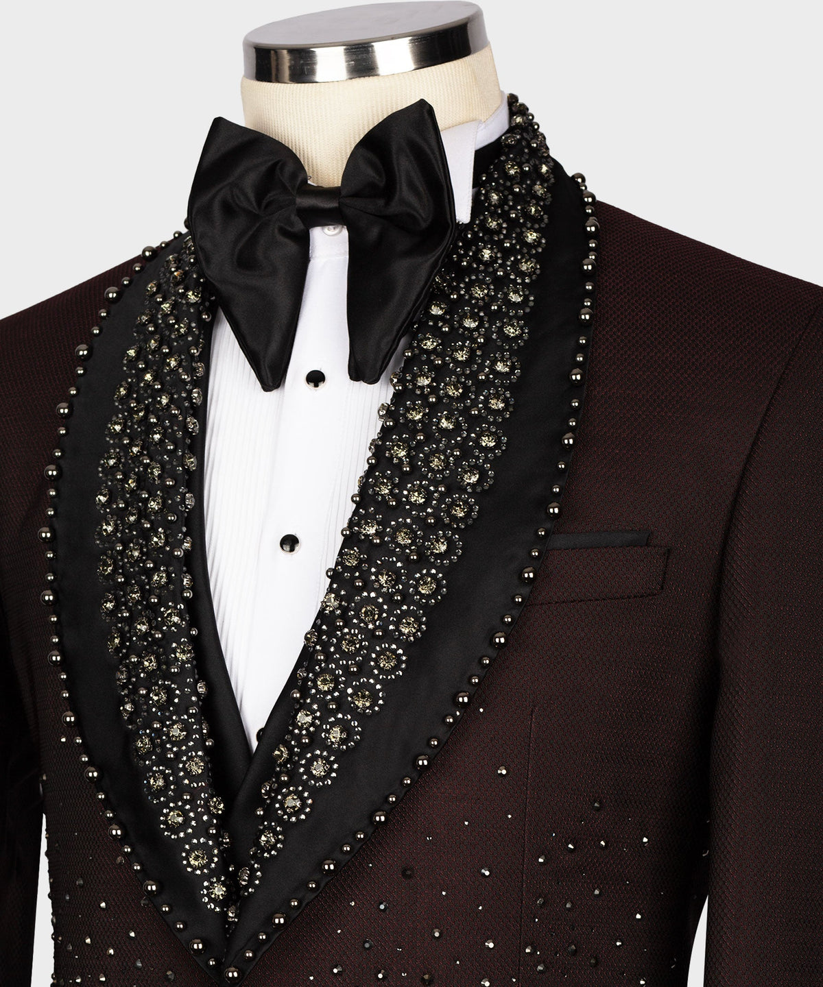 Burgundy tuxedo close-up with black bow tie, jeweled lapel trim, and chest pocket