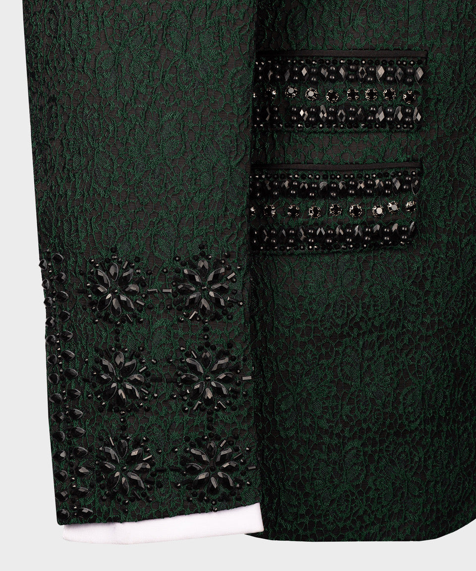 Close-up of green tuxedo jacket sleeves and cuffs with black beaded trim and studded panel