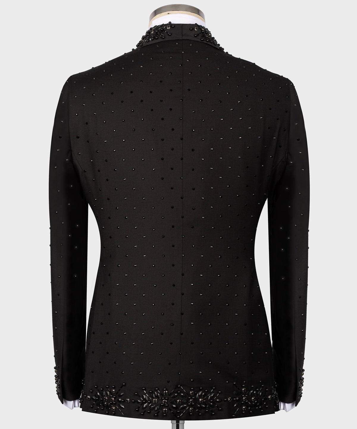 Back view of black tuxedo jacket with dotted beaded pattern and ornate hem detail