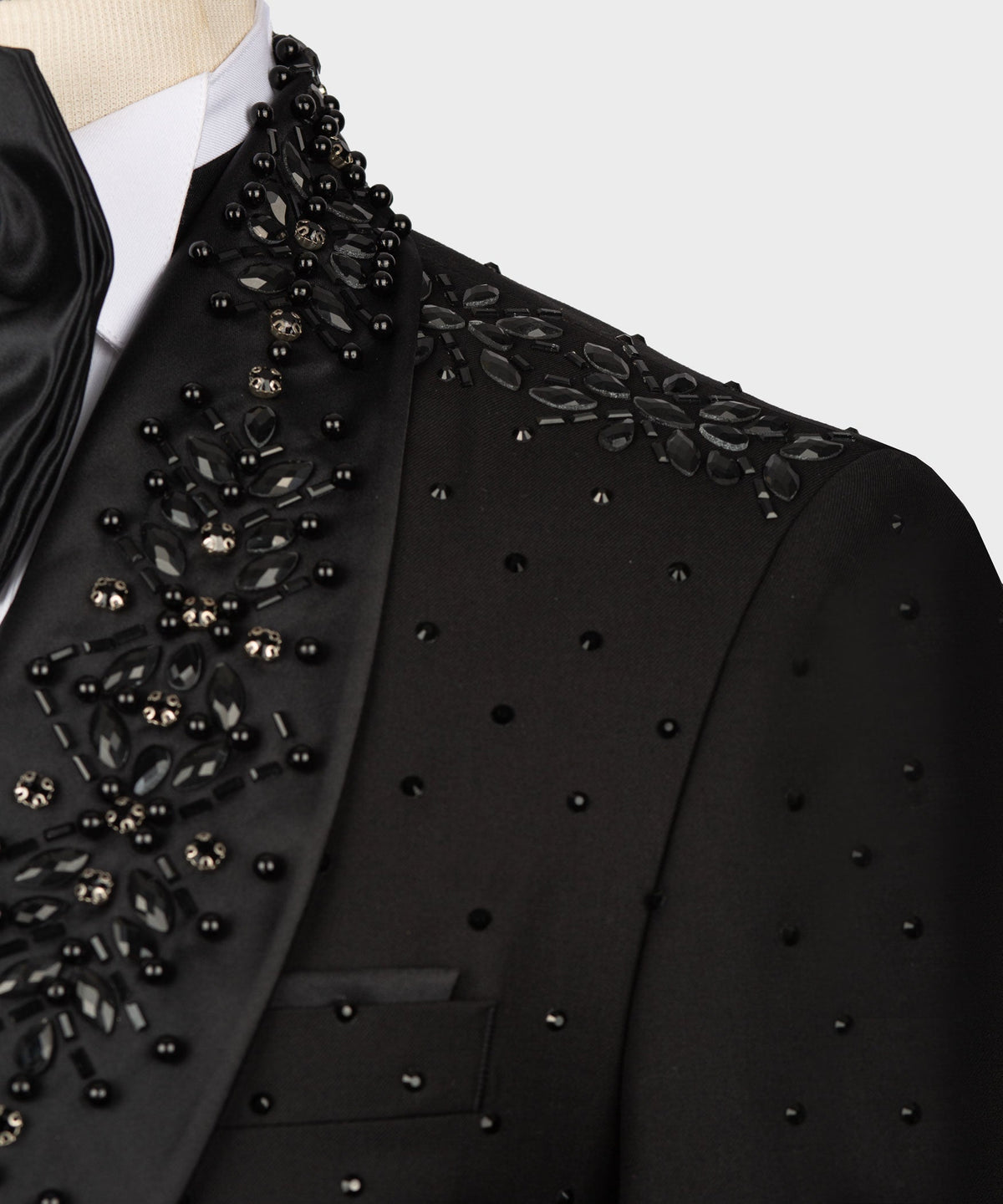 Close-up of black tuxedo lapel with ornate beaded and gem-like embellishments