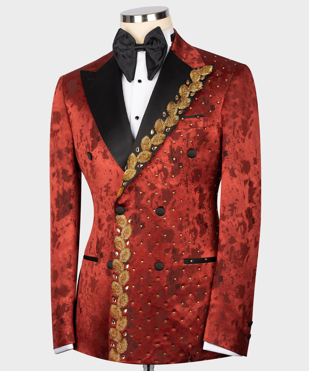Front view red tuxedo jacket with black lapels, bow tie, and gold baroque embroidery