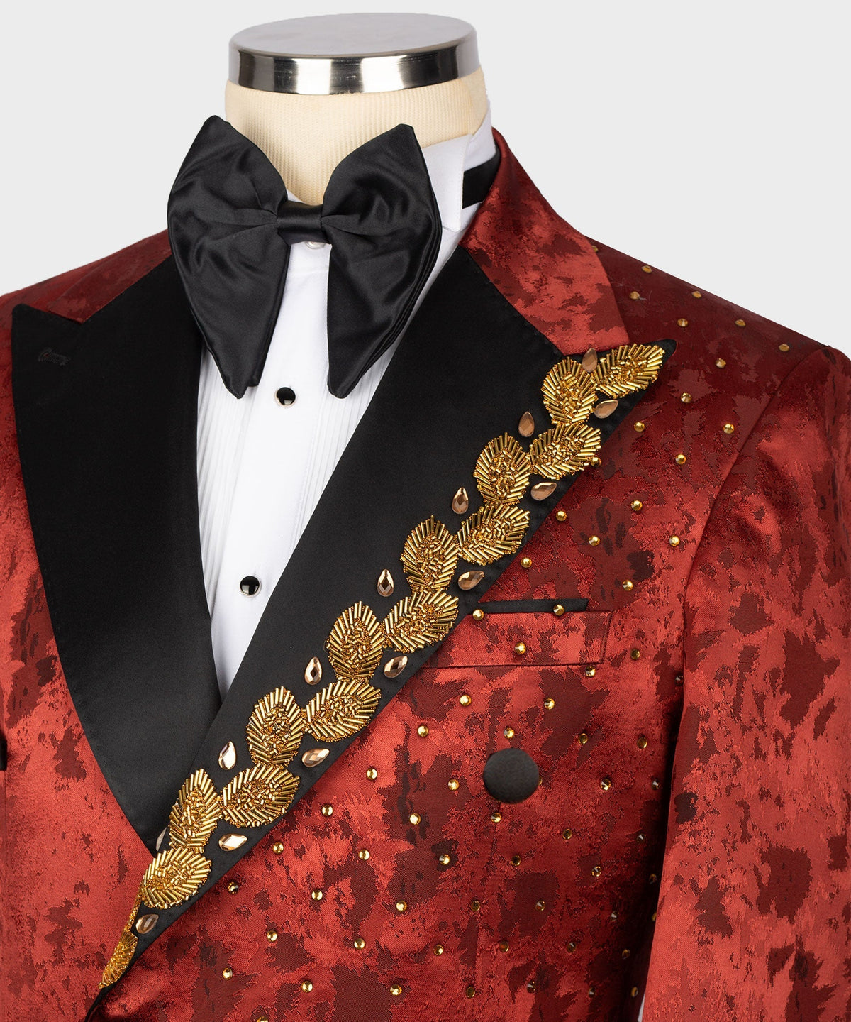 Red patterned tuxedo jacket close-up with gold embroidered diagonal trim and black lapels