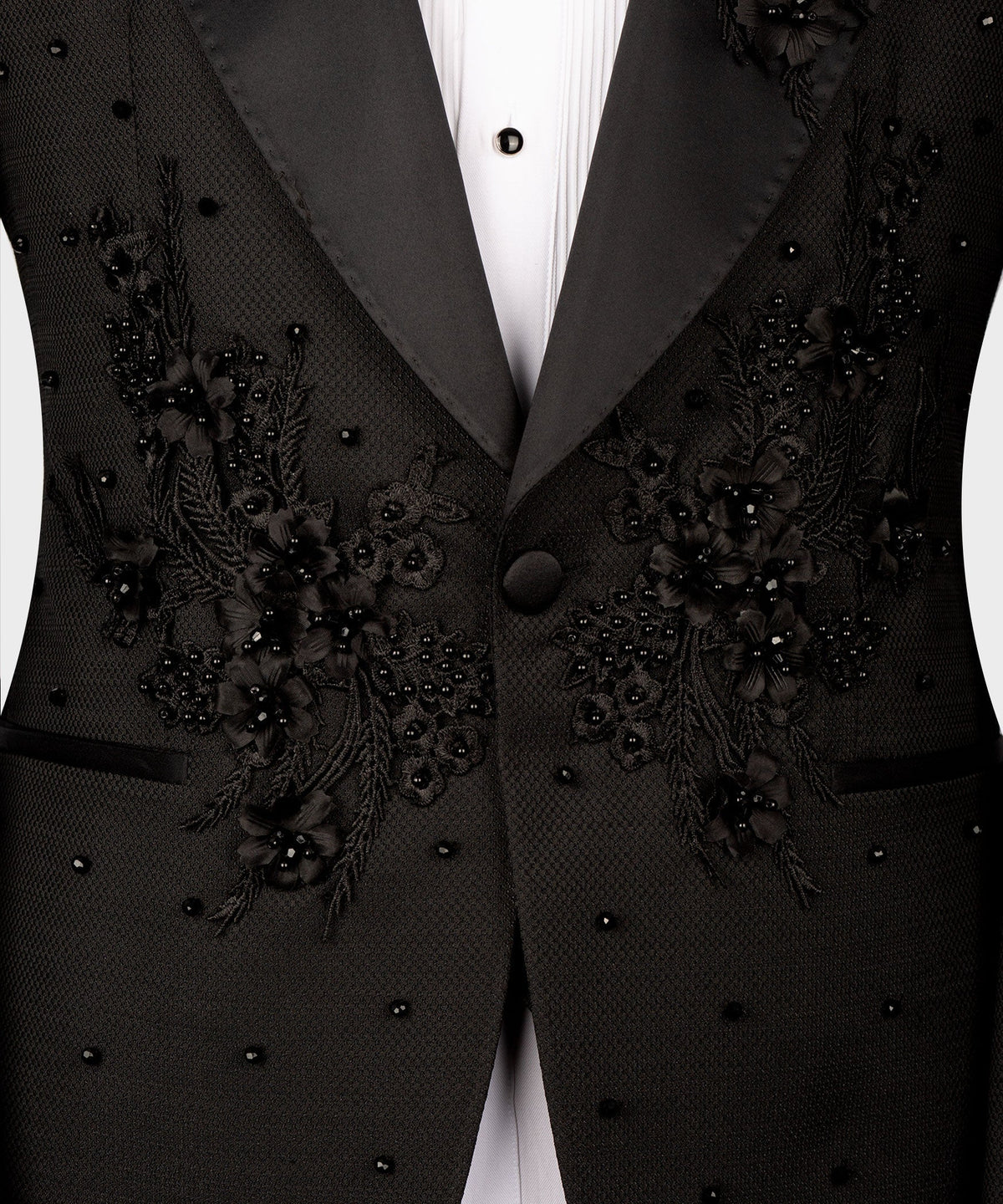 Close-up of black tuxedo jacket front with floral embroidery on satin lapels