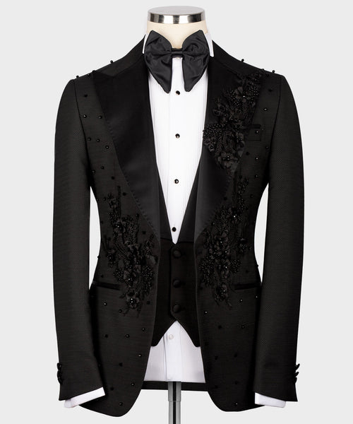 Black tuxedo jacket with floral embroidery, satin lapels, and matching bow tie