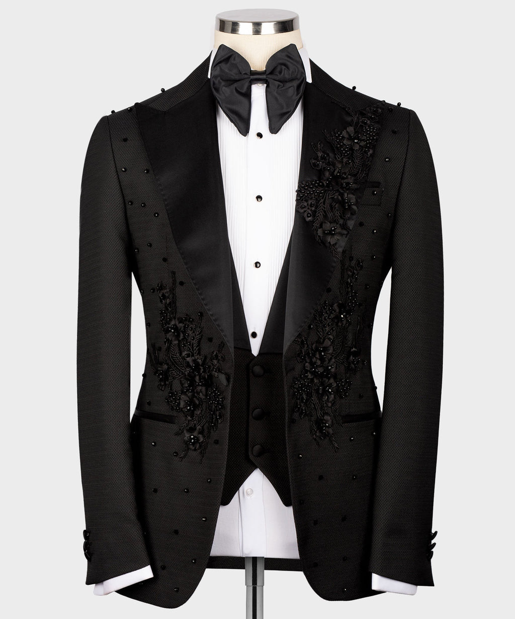 Black tuxedo jacket with floral beaded appliqué, satin bow tie, and white shirt front