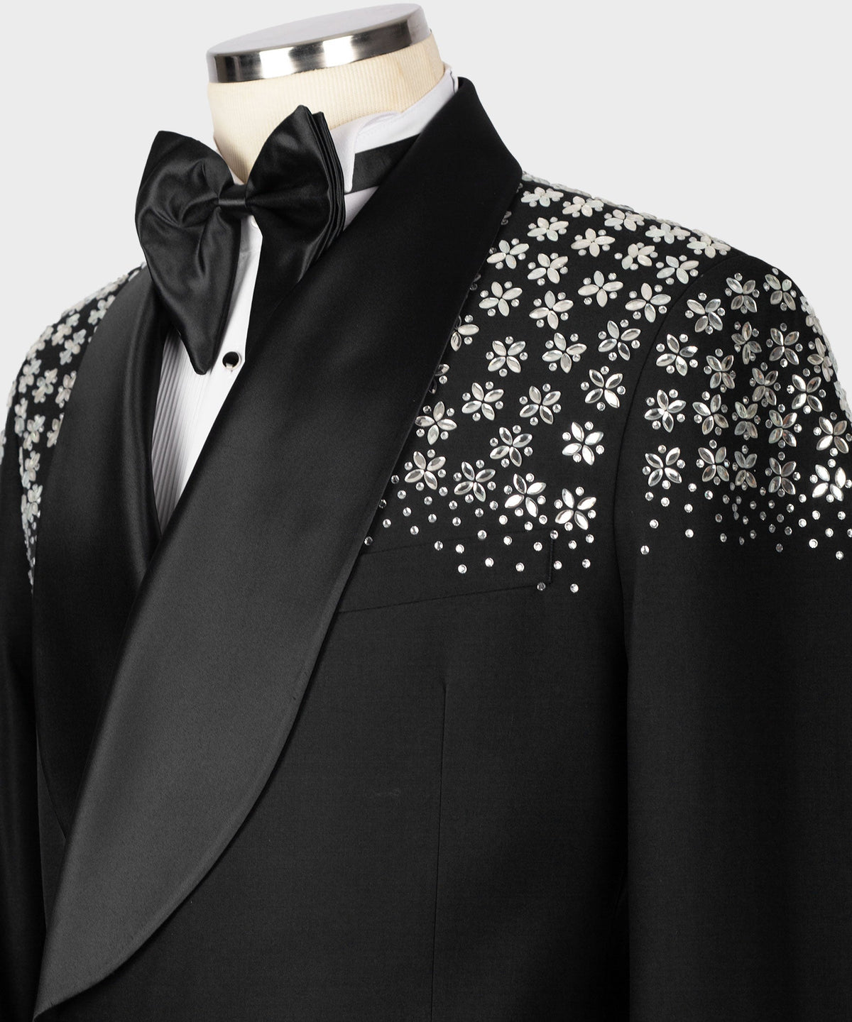 Close-up black tuxedo lapel with bow tie and floral stone embroidery
