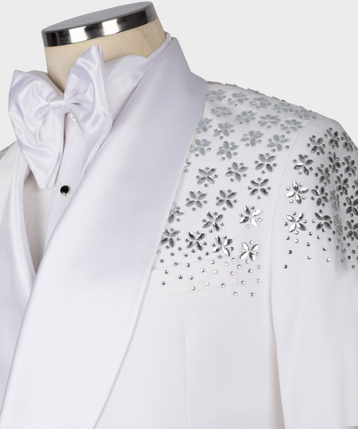 White tuxedo collar with oversized bow tie; rhinestone floral shoulder ornament detail