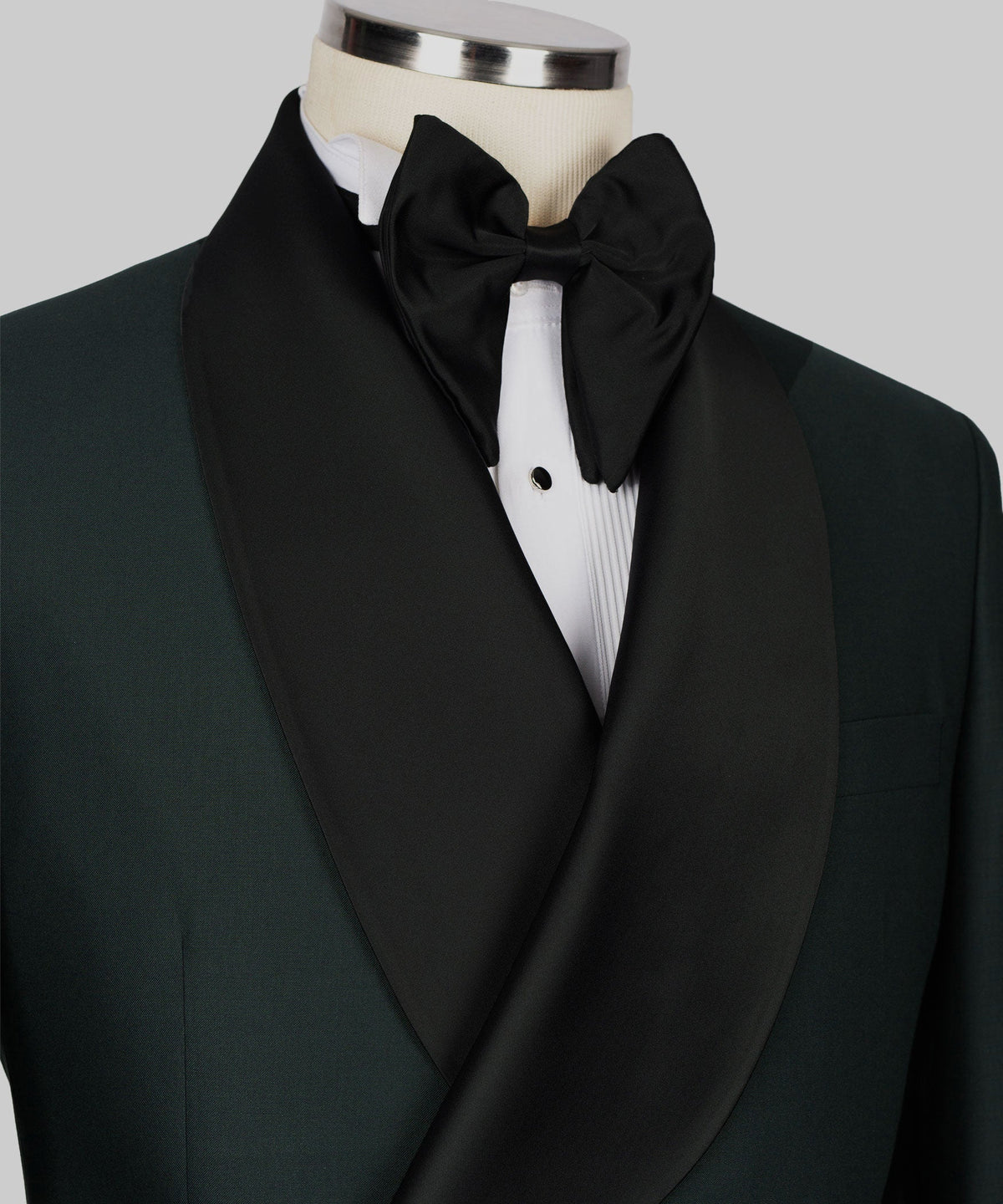 Close-up of black satin bow tie and shawl lapel on green tuxedo jacket