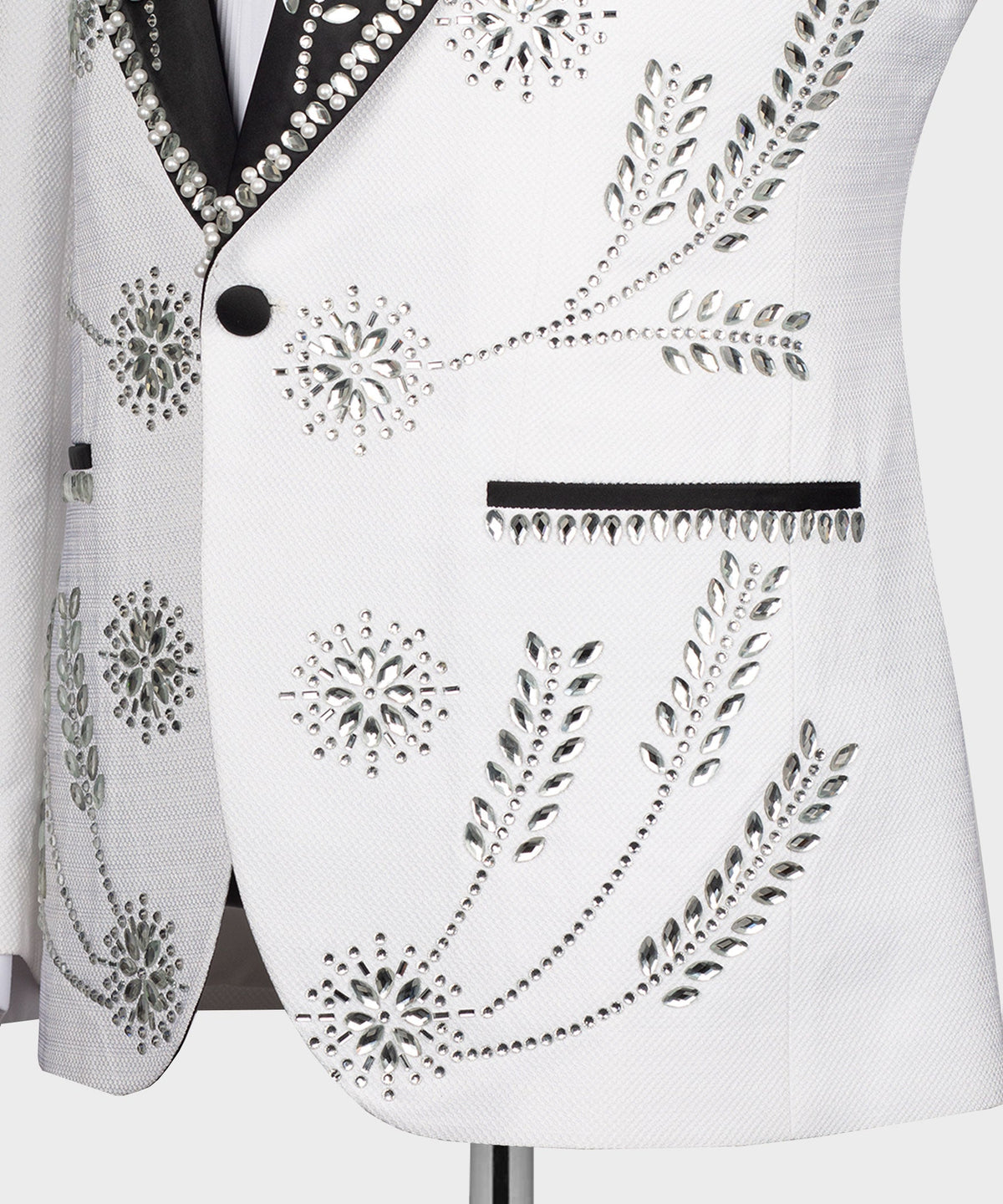 Close-up of white tuxedo jacket front with rhinestone buttons and beaded design panel