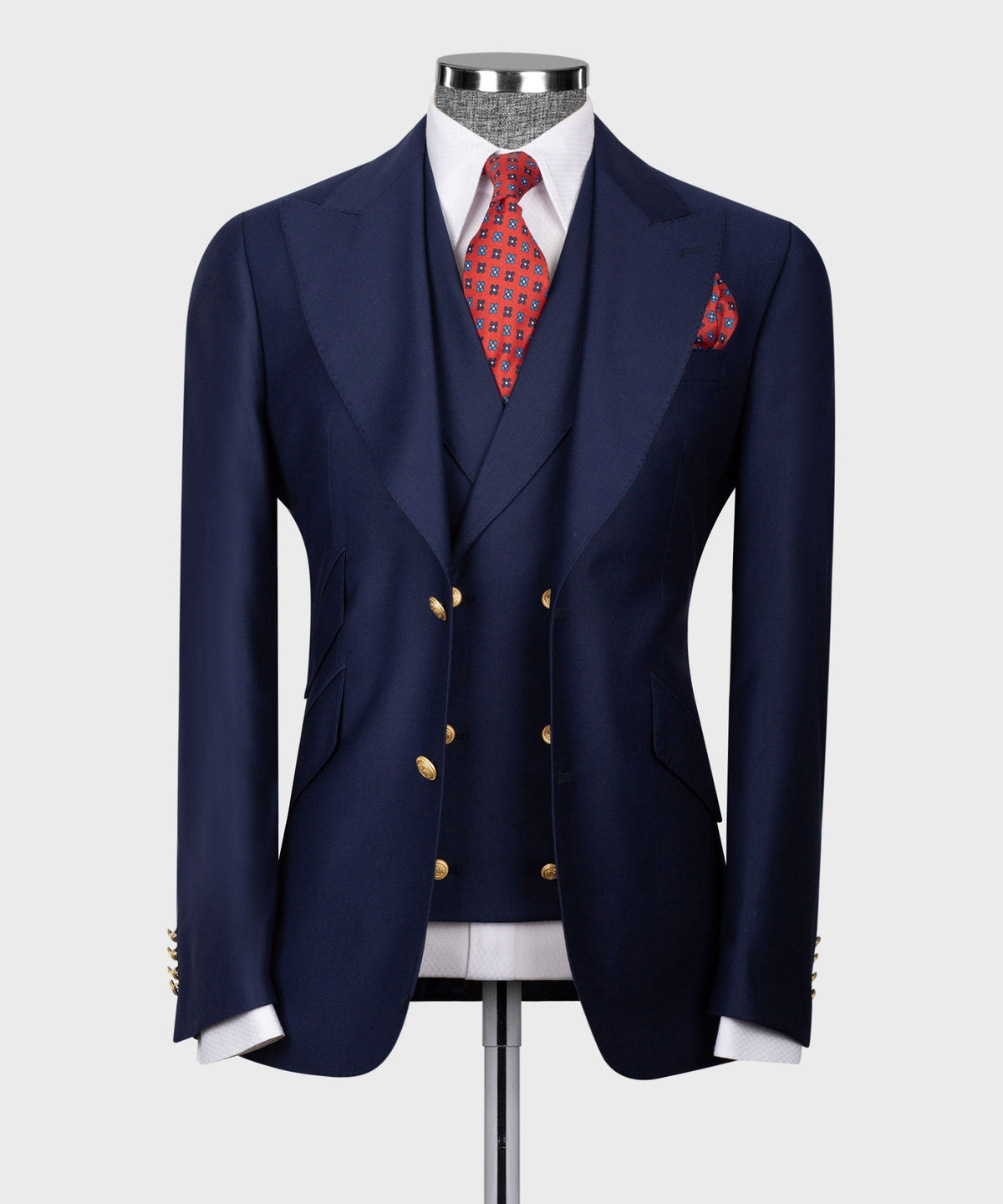 Navy blue vest suit jacket with gold buttons, red patterned tie and pocket square