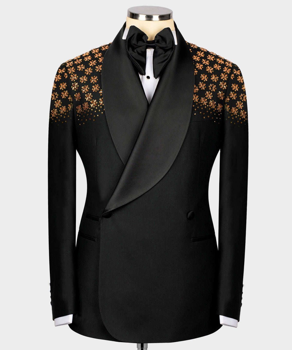 Black tuxedo jacket with gold floral embellished panels and satin bow, on mannequin.