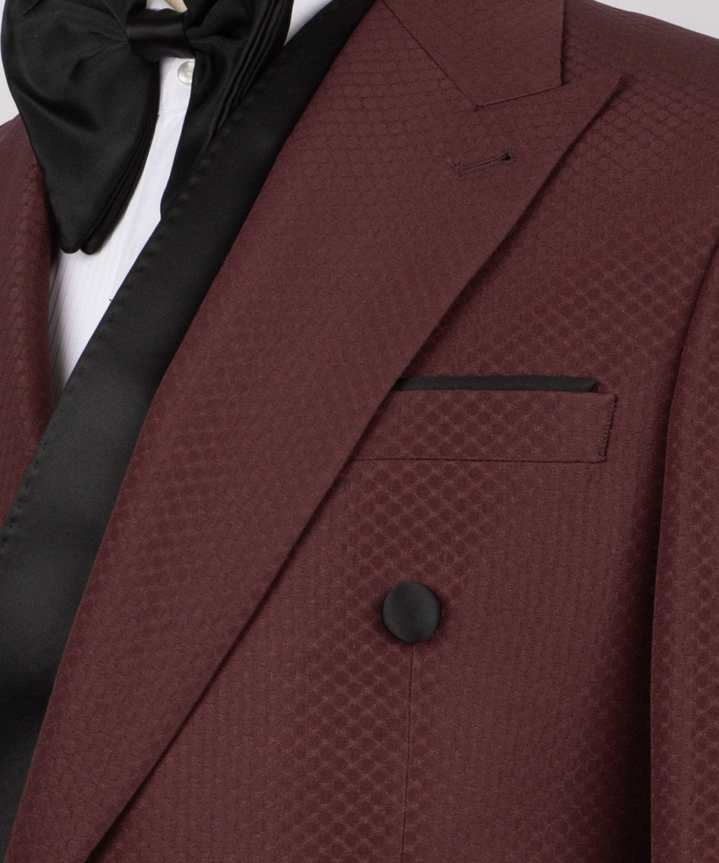 Close-up of burgundy textured tuxedo lapel, pocket square, and black satin accents