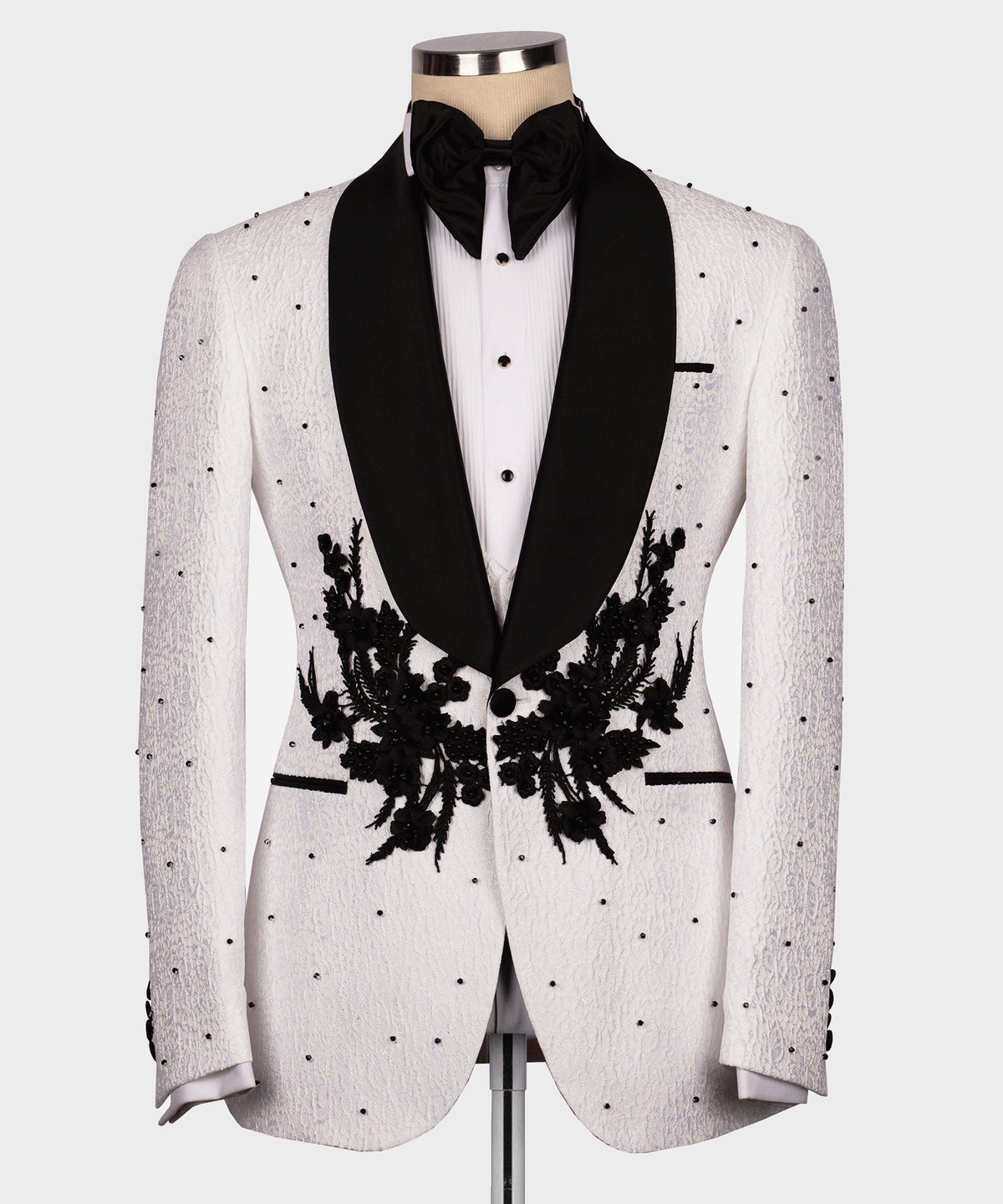 White tuxedo jacket with black lapels and floral appliqué, black bow tie and white shirt