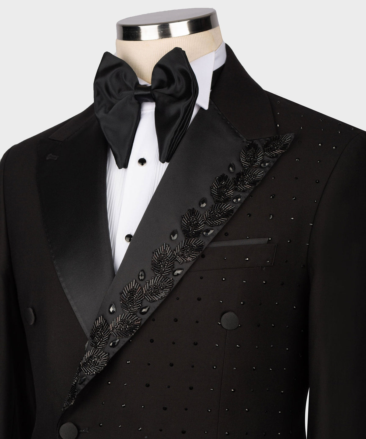 Black tuxedo jacket close-up: rhinestone diagonal trim over dotted front panel