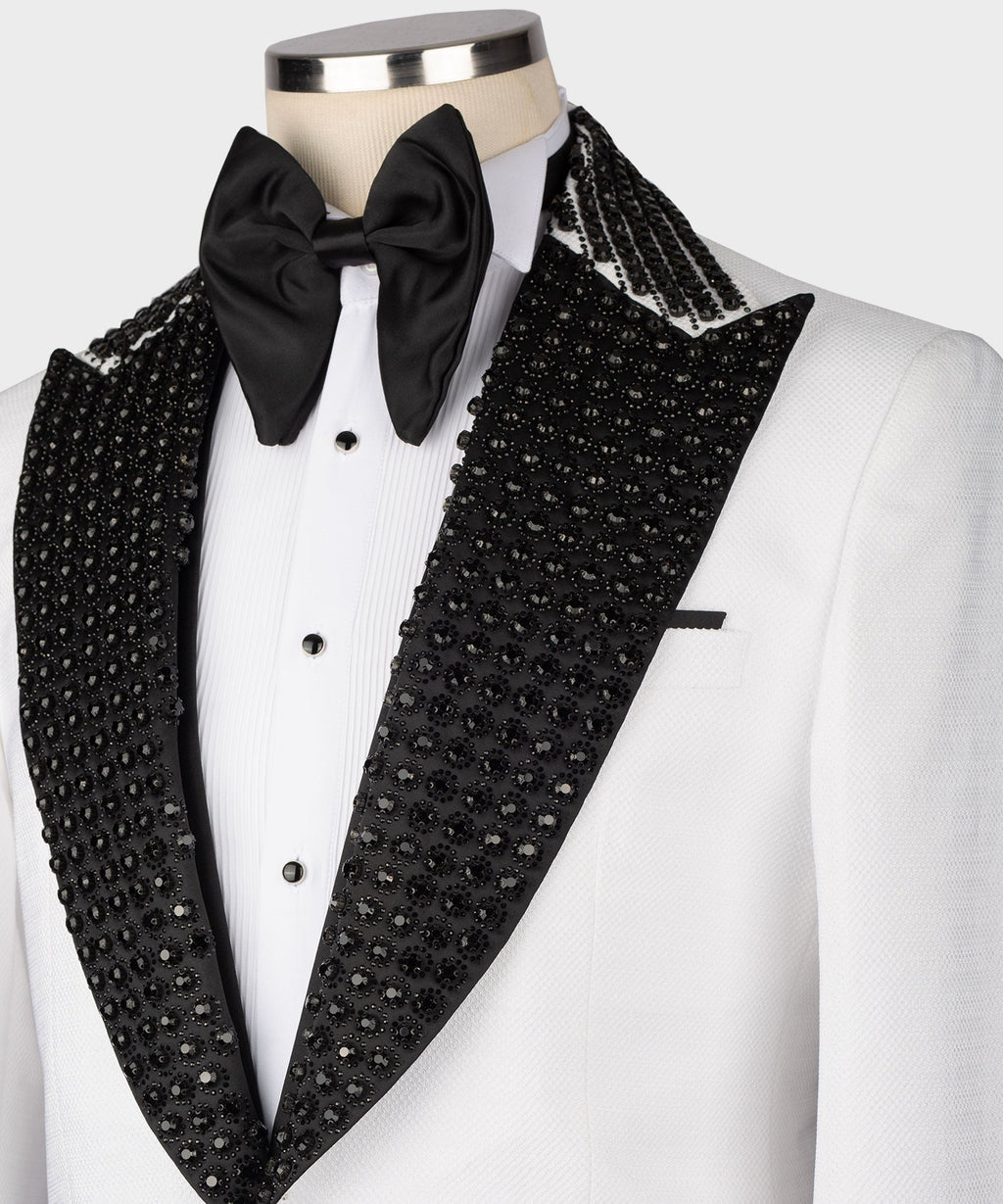 Black stone-embroidered lapels and vest with bow tie; white tuxedo jacket close-up