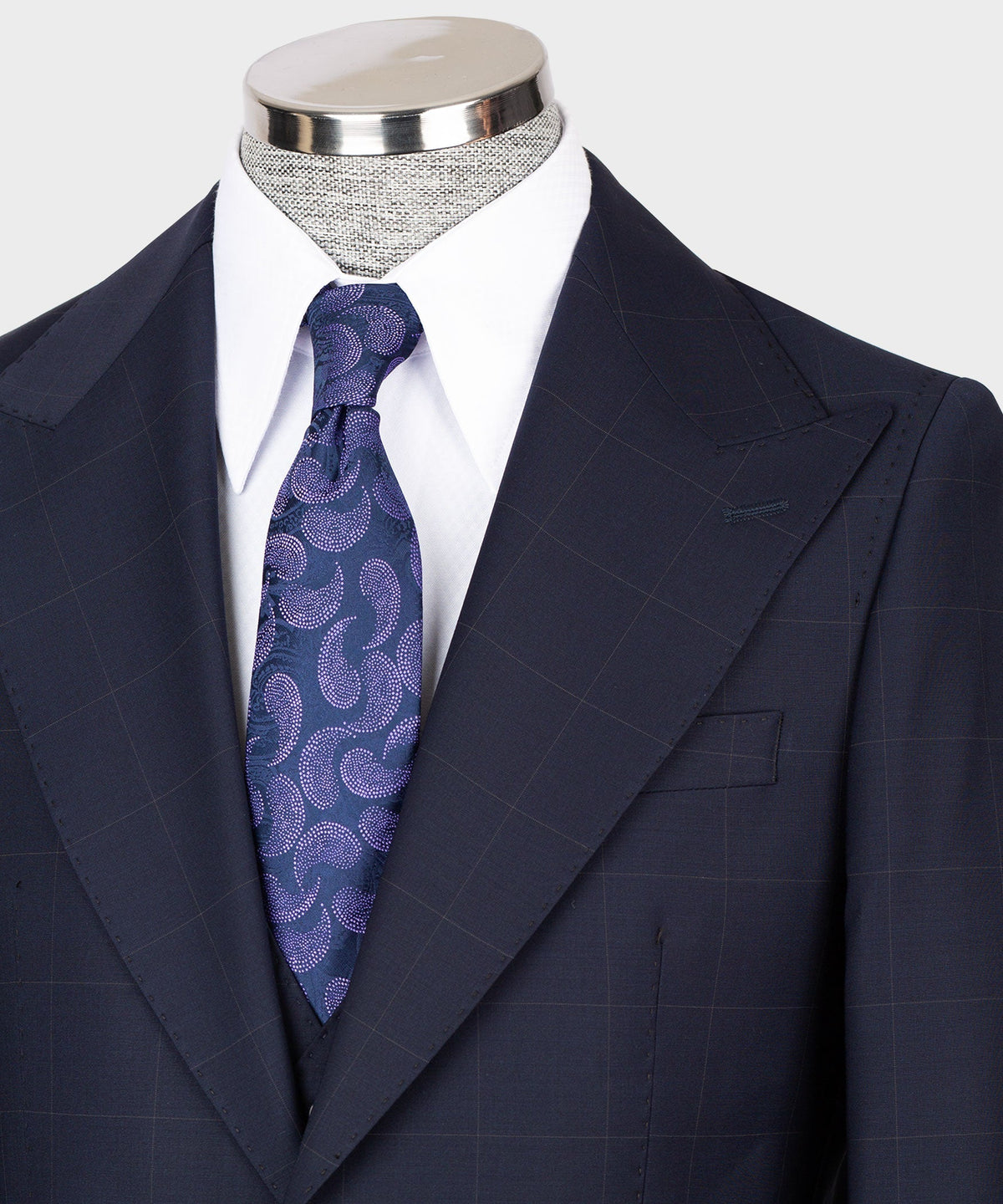 Navy suit jacket lapels and vest, blue-purple patterned tie, white shirt