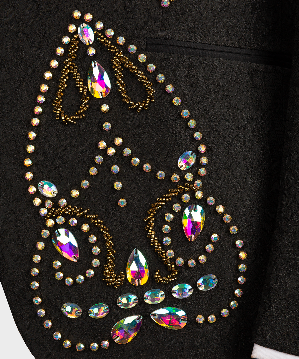 Close-up of black tuxedo lapel: gold beadwork with multicolor rhinestone accents