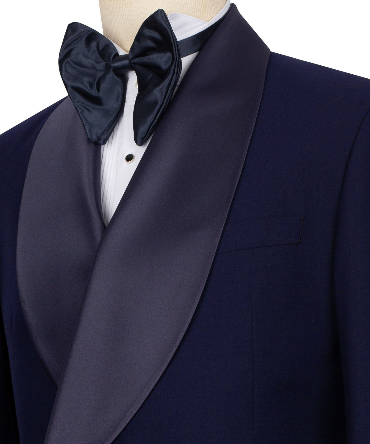 Navy tuxedo jacket close-up: satin shawl lapel, black bow tie, white shirt