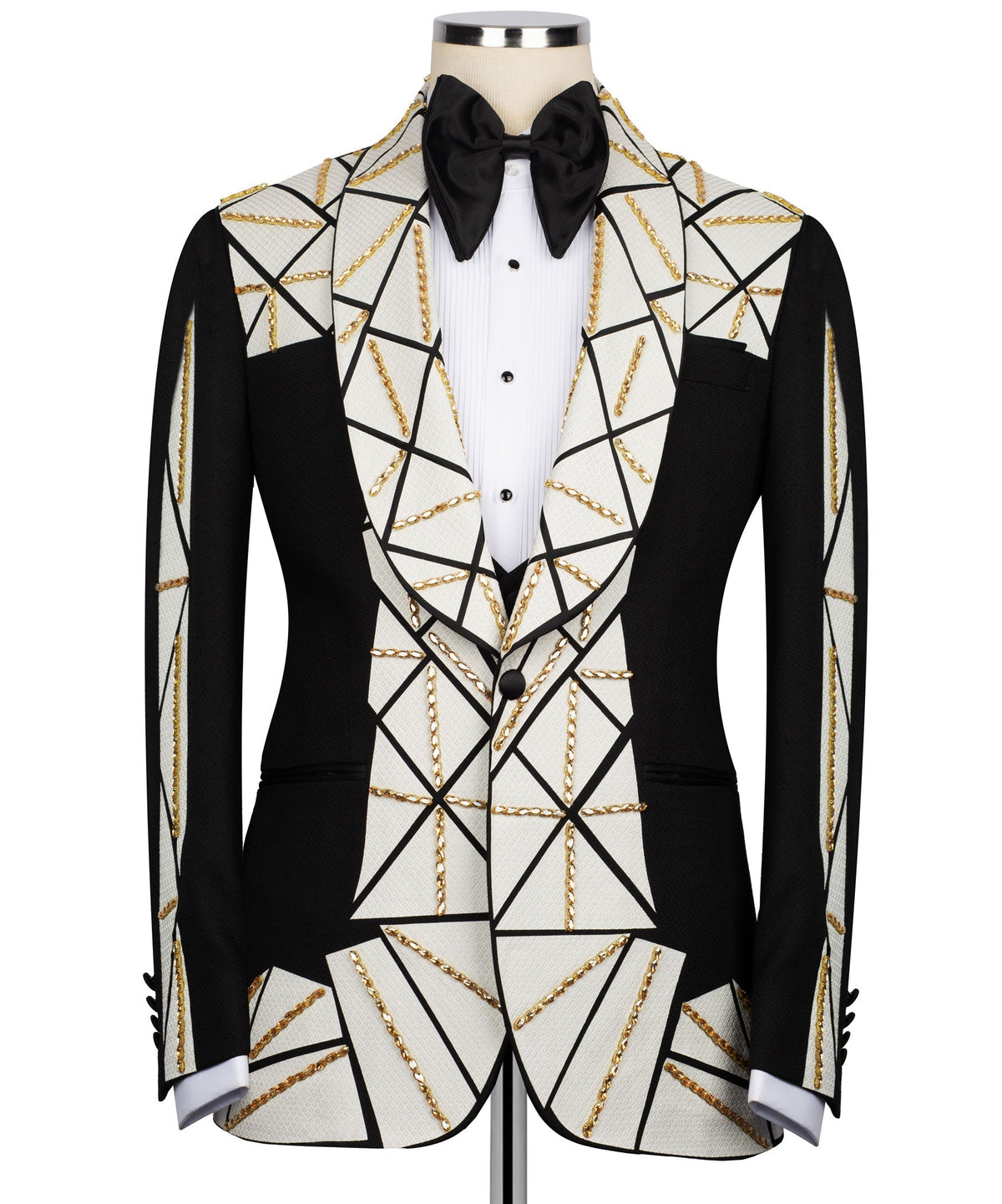 Tuxedo suit with black satin bow tie, white vest with black buttons, gold chain details