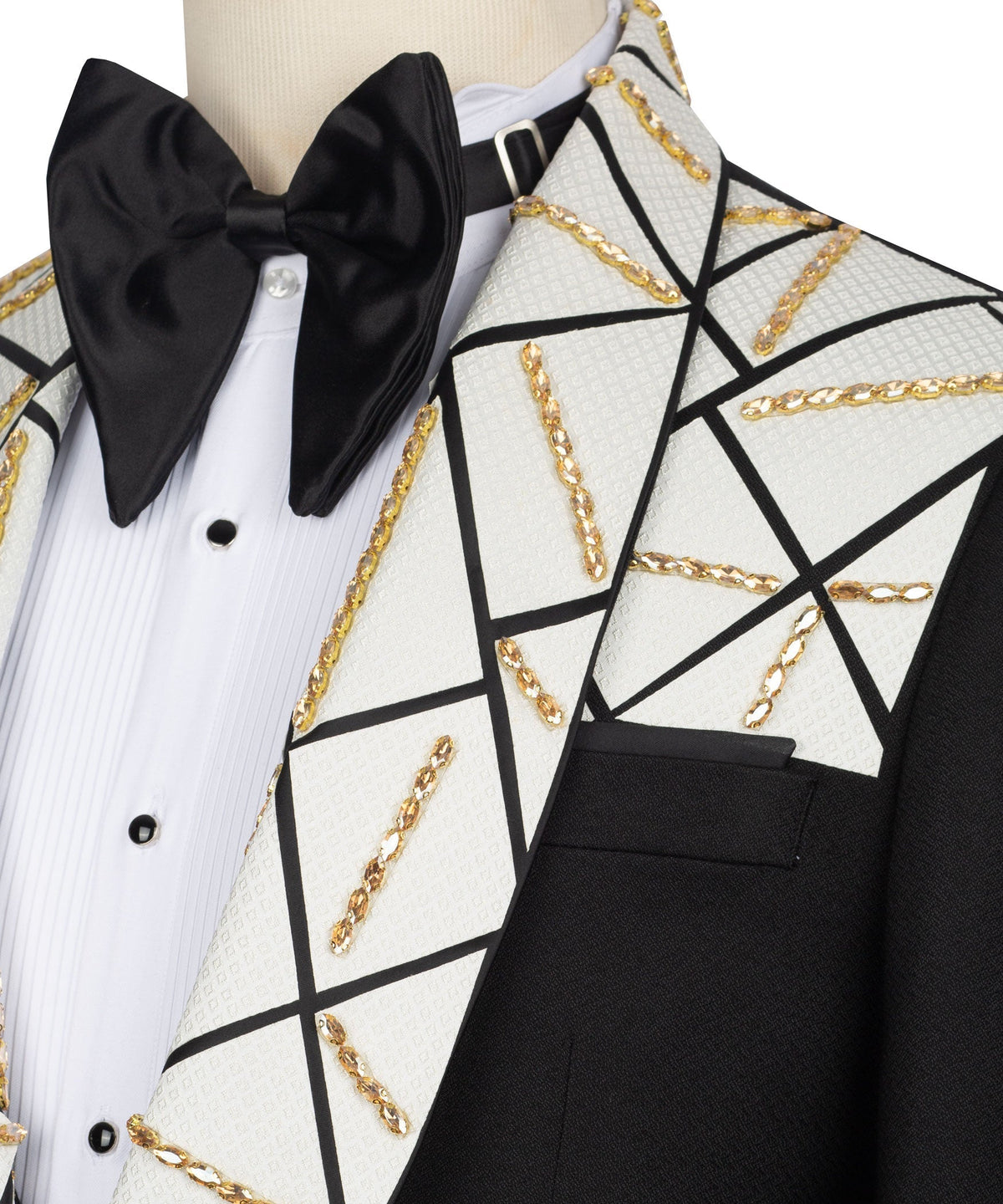 Close-up bow tie and patterned lapels with gold chain trim on black-and-white tuxedo
