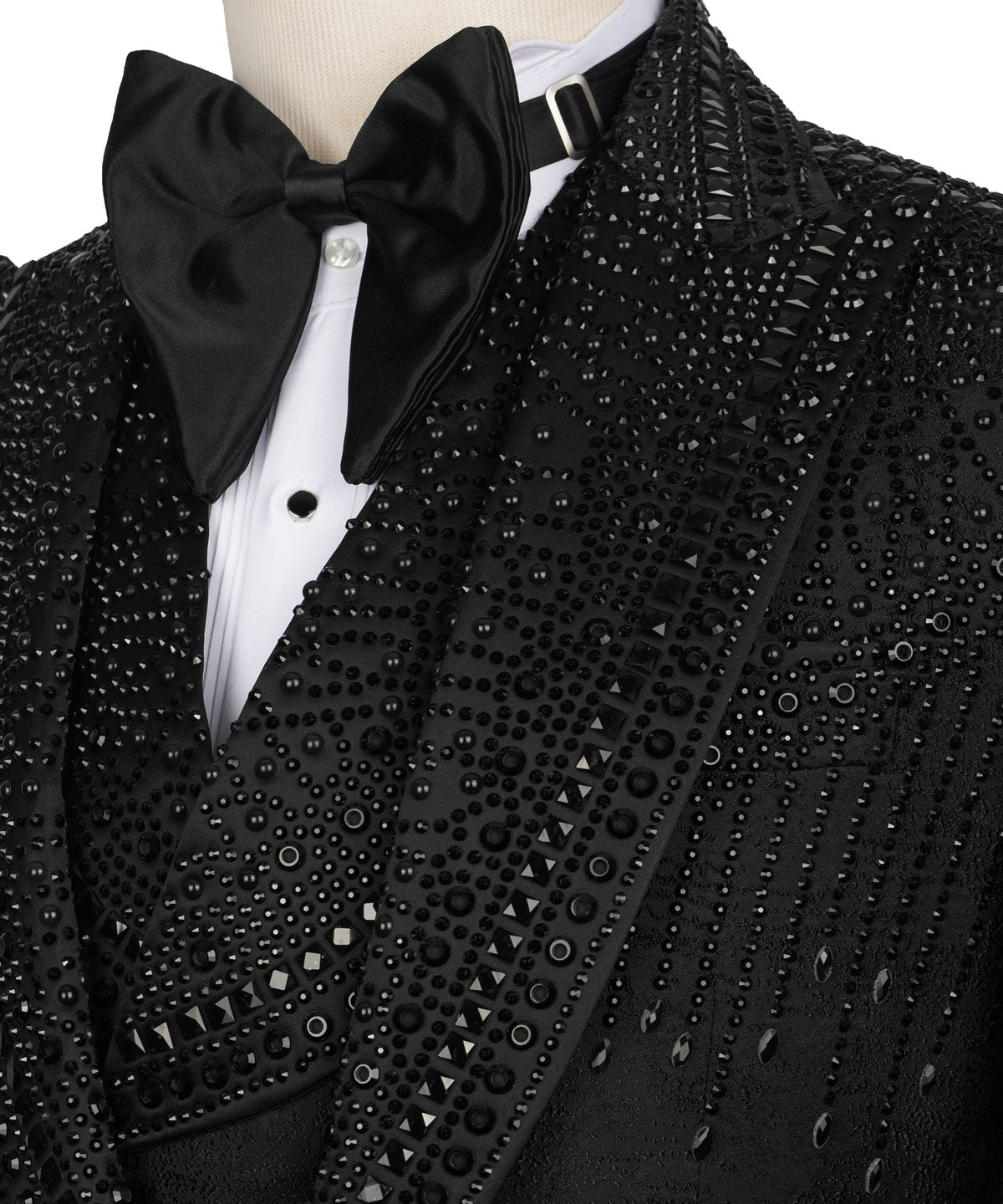 Close-up of black tuxedo jacket lapels with bow tie and stone-studded detailing