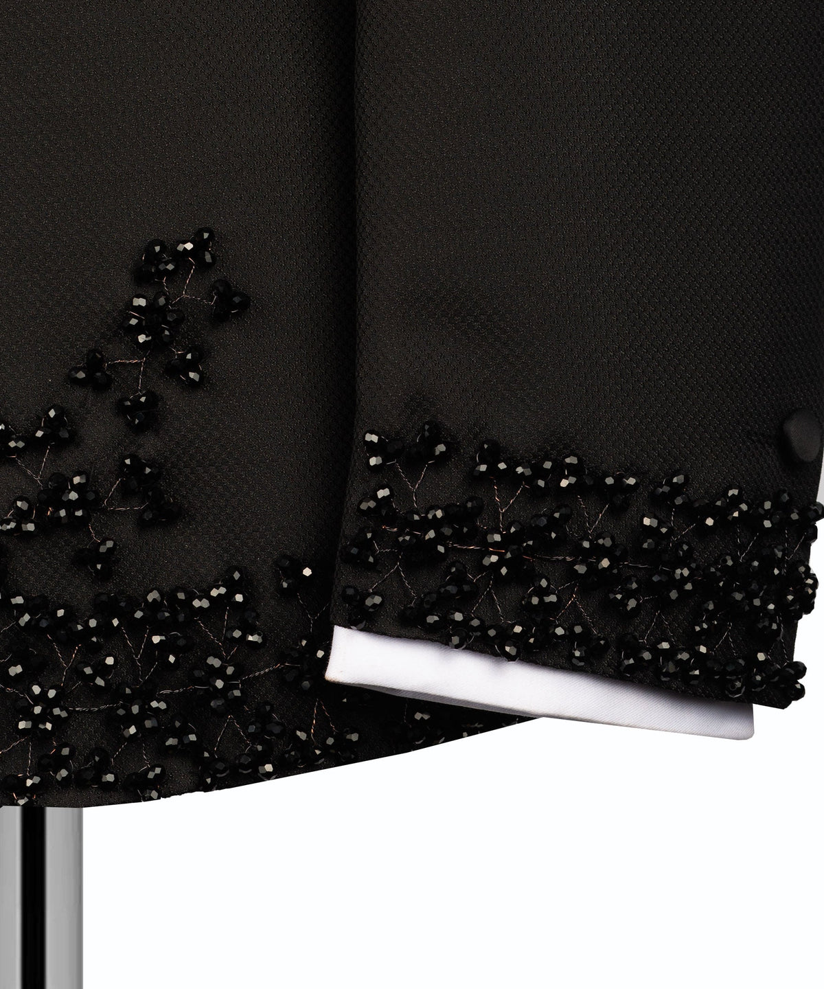 Black tuxedo sleeve cuff with beaded stone trim over white shirt cuff