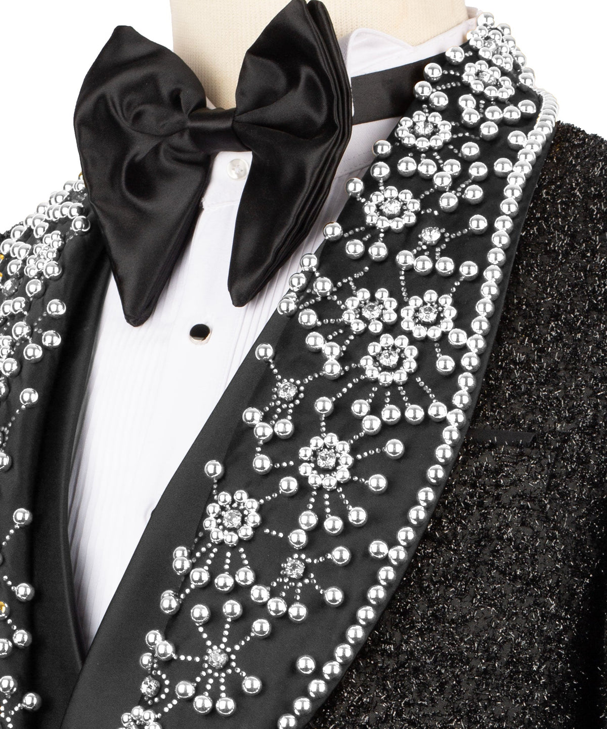Close-up of black satin bow tie and white gem-like beaded lapel trim on tuxedo