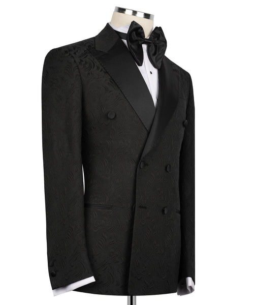 Black tuxedo jacket with oversized bow tie, double-breasted buttons, patterned fabric