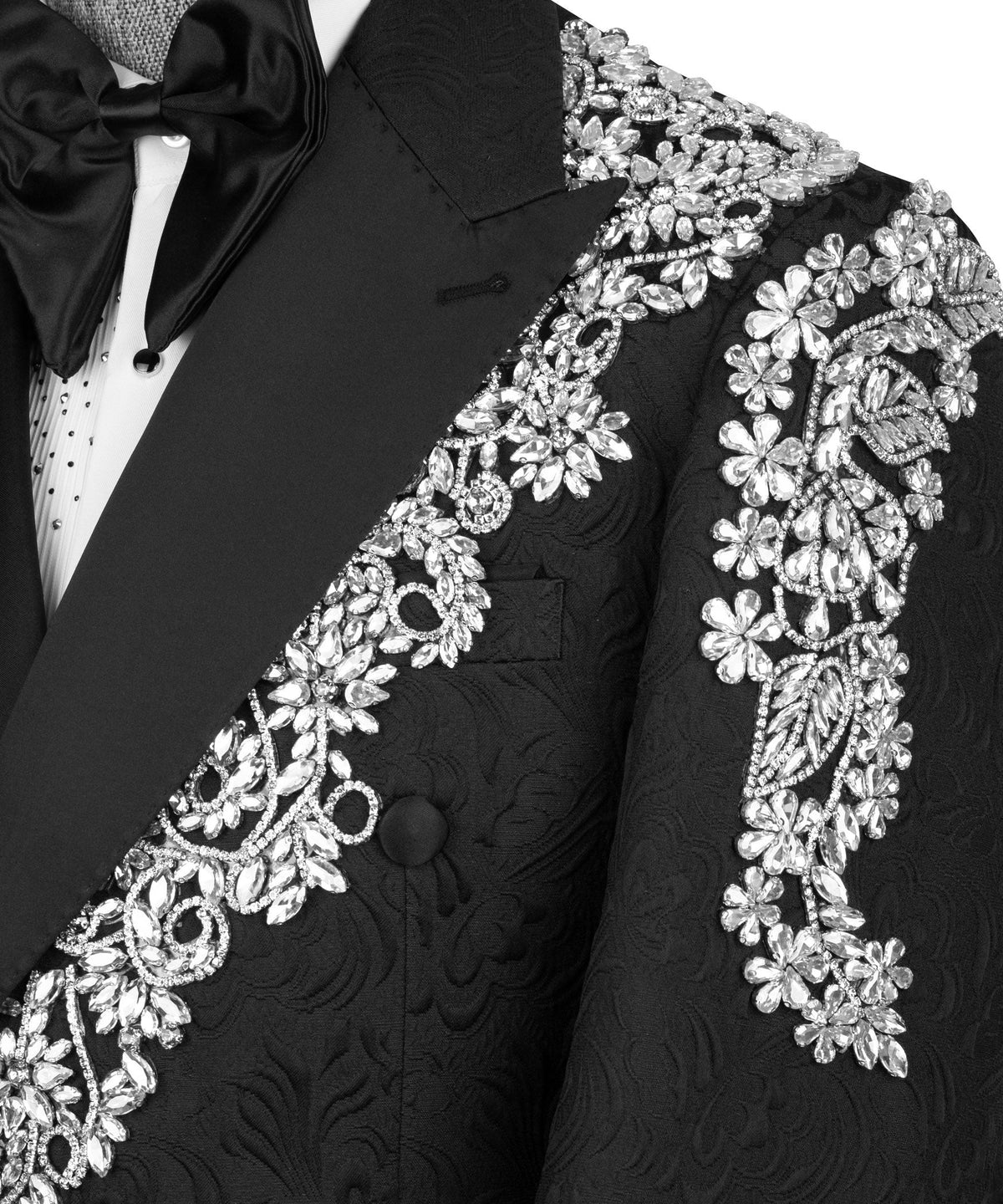 Close-up black tuxedo lapel with sparkling stone floral embroidery and mirrored motifs