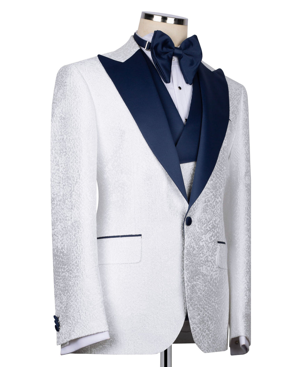 White tuxedo jacket with dark blue lapels, button front, pocket detail, bow at neck.
