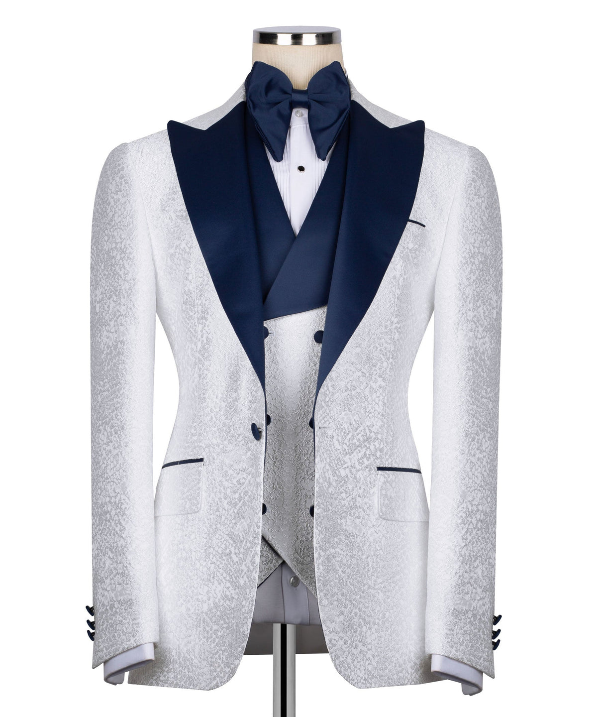White tuxedo jacket with dark blue lapels and bow tie accents, textured stone-like fabric.