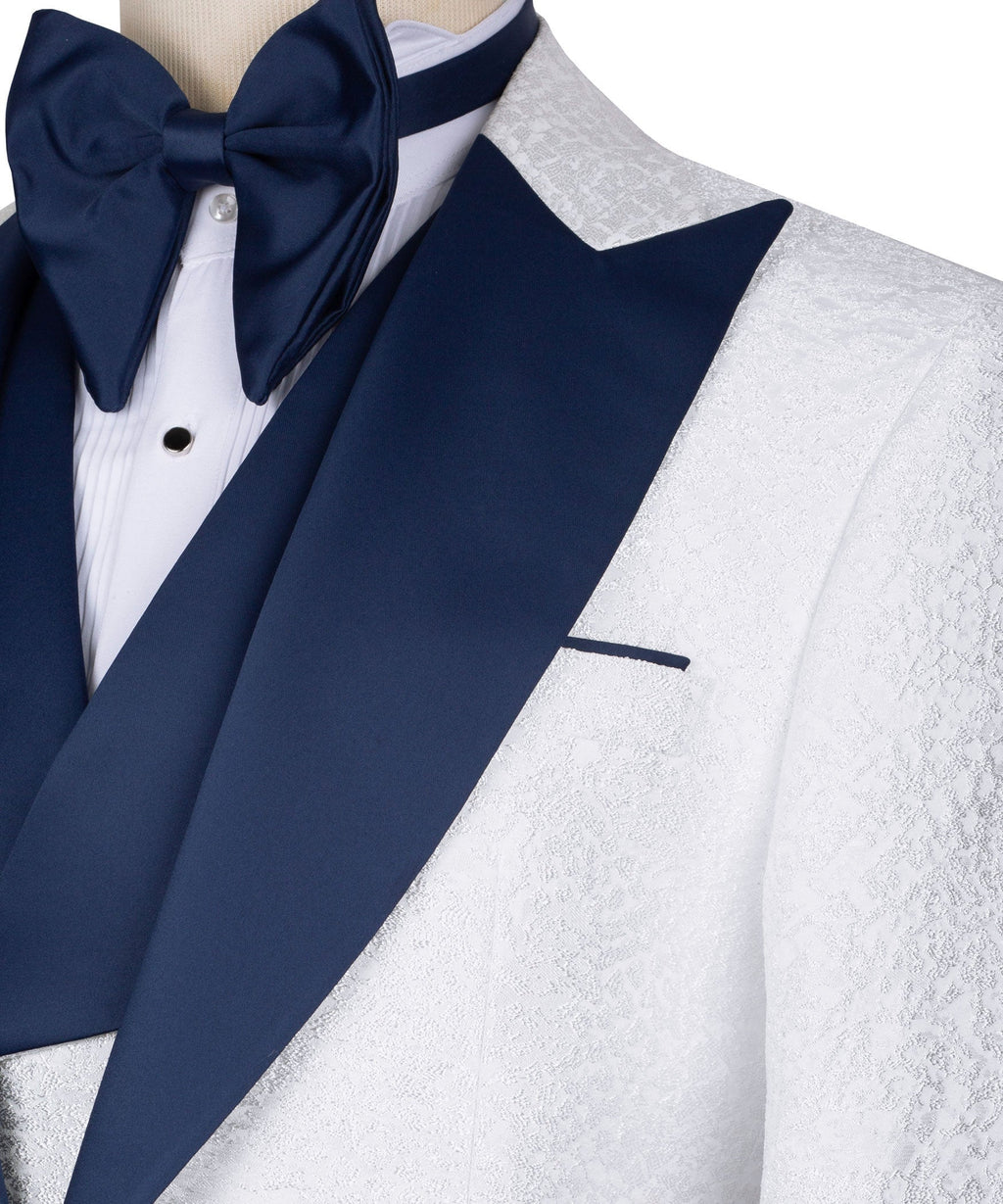 Dark blue lapel and bow tie detail on white tuxedo jacket with textured fabric.