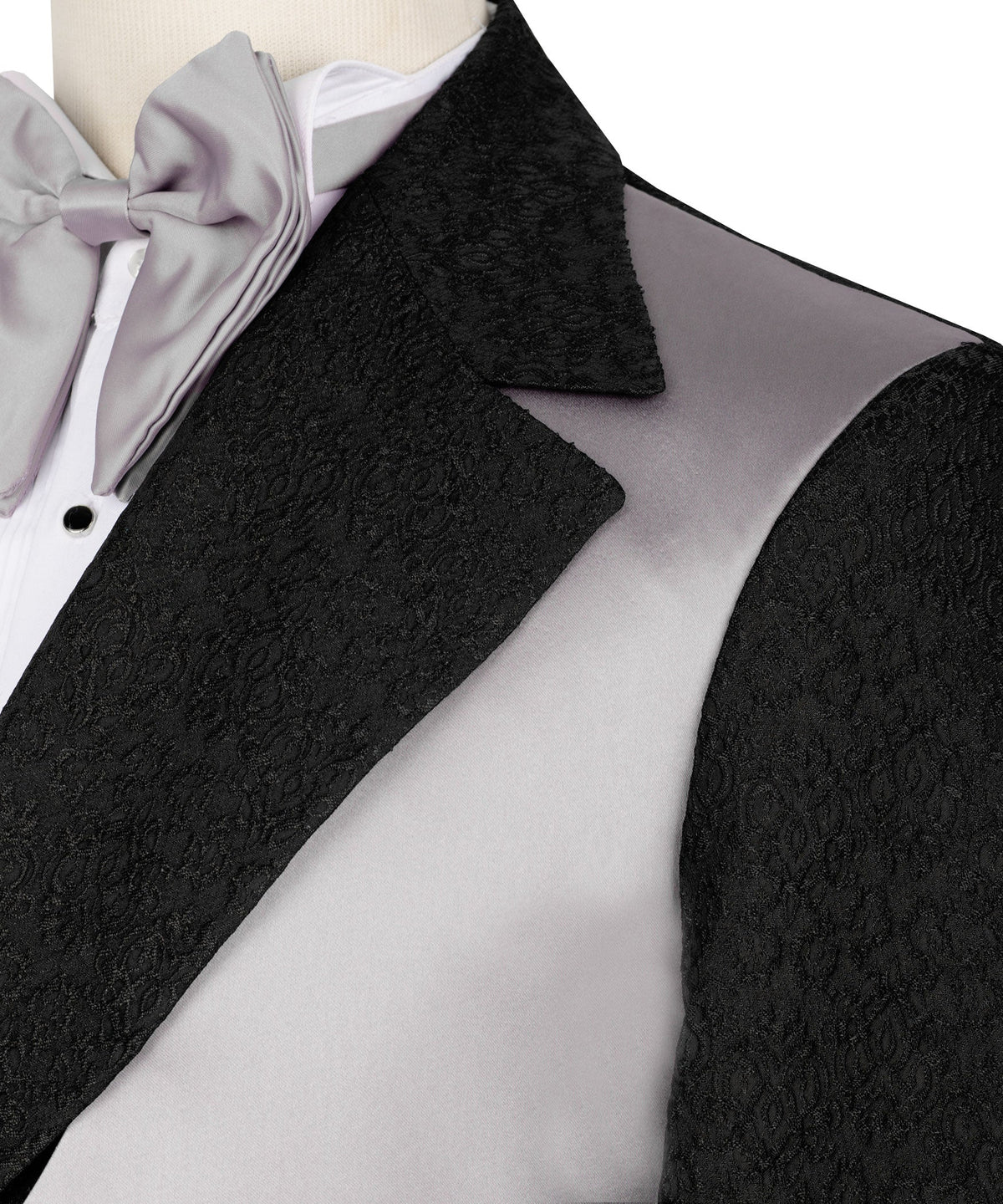 Close-up: black textured lapel, light-gray satin vest, and light-gray bow tie