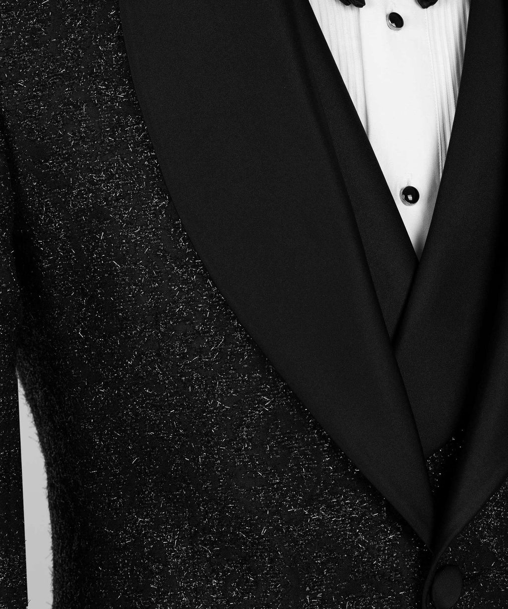 Close-up of black satin V-lapel on glitter tuxedo jacket