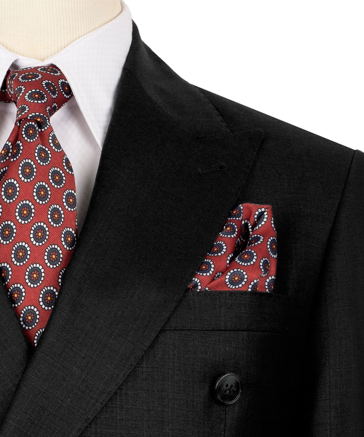 Close-up of black blazer lapel with red patterned tie and pocket square