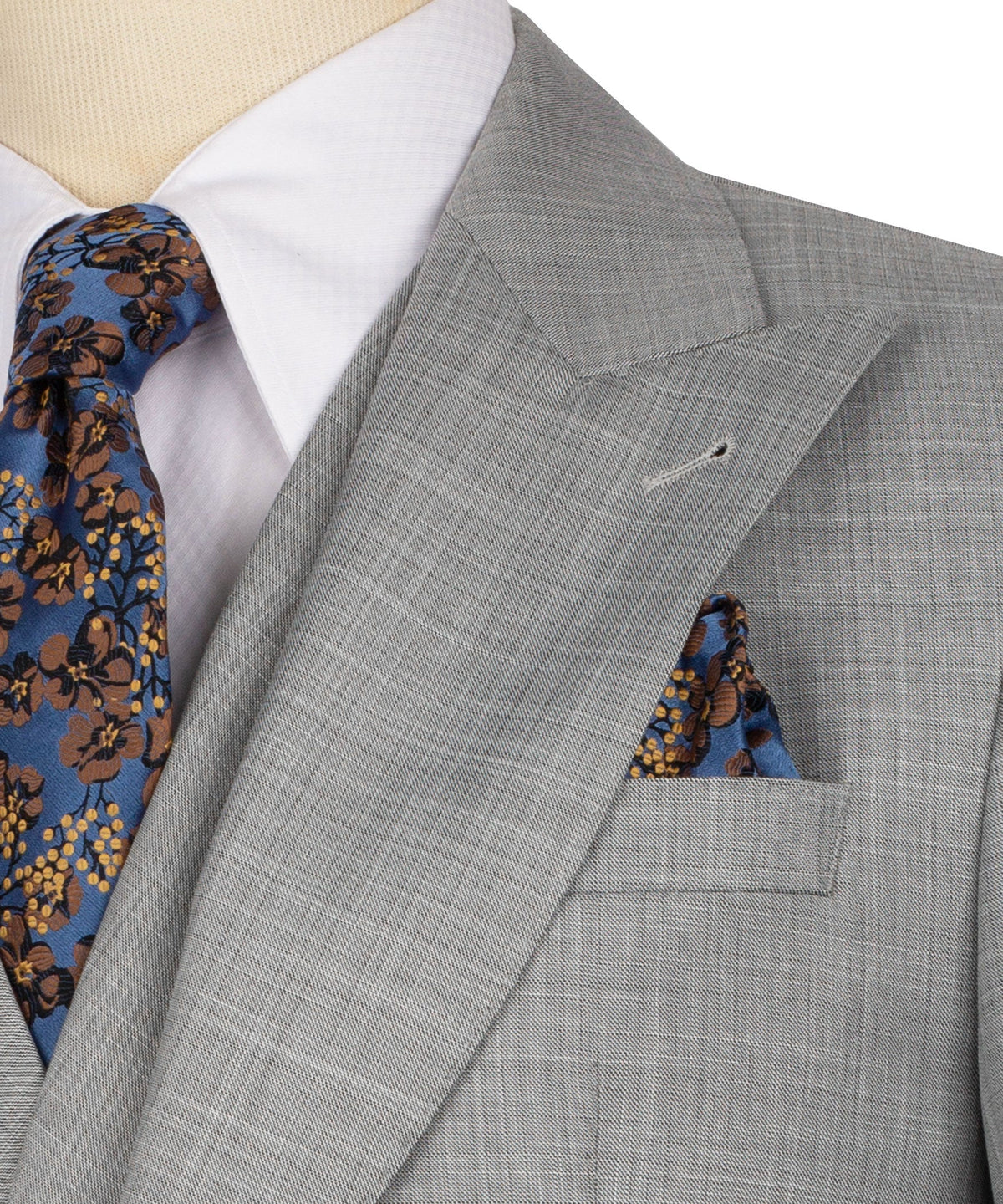 Grey suit lapel detail with patterned tie and blue floral pocket square